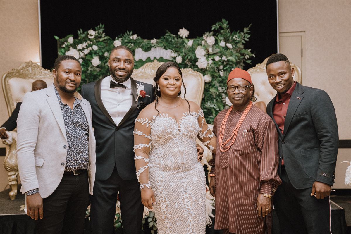 A newlywed couple with family at their wedding reception